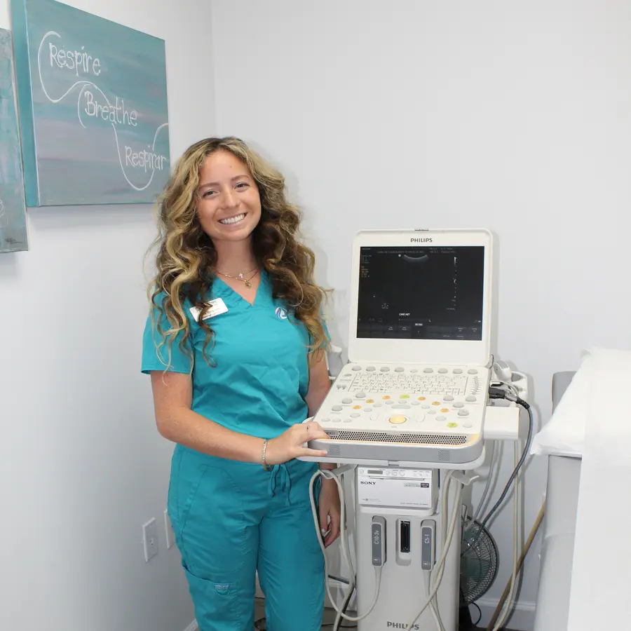 A Care Net sonographer beside the ultrasound machine.